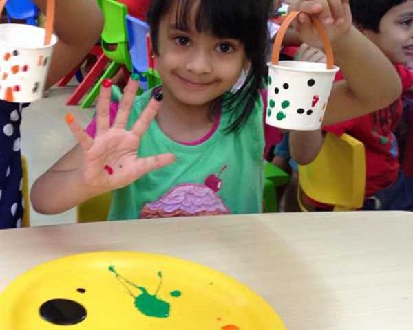 A Little Girl sitting at a table in a birthday party.