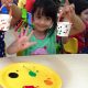 A Little Girl sitting at a table in a birthday party.