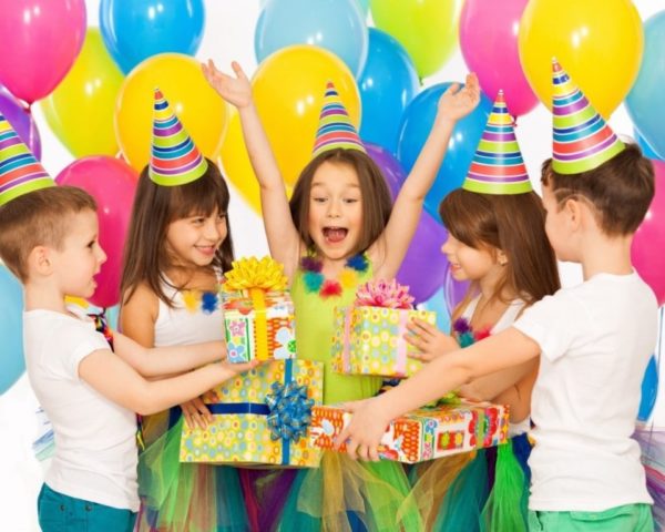 Happy Child Receiving Gifts From Her Friends In Her Birthday Party.